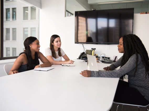 Three people sitting around a conference table