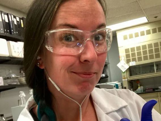 Sarrah Hannon in a lab giving a thumbs up.