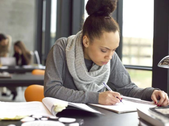 person focused and writing at desk