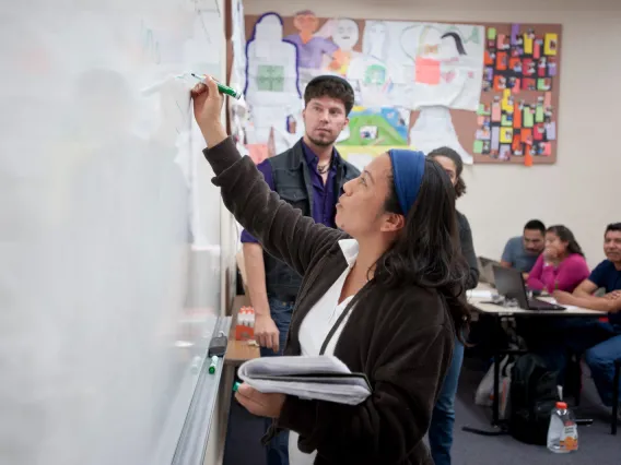 working at the board in a diverse classroom