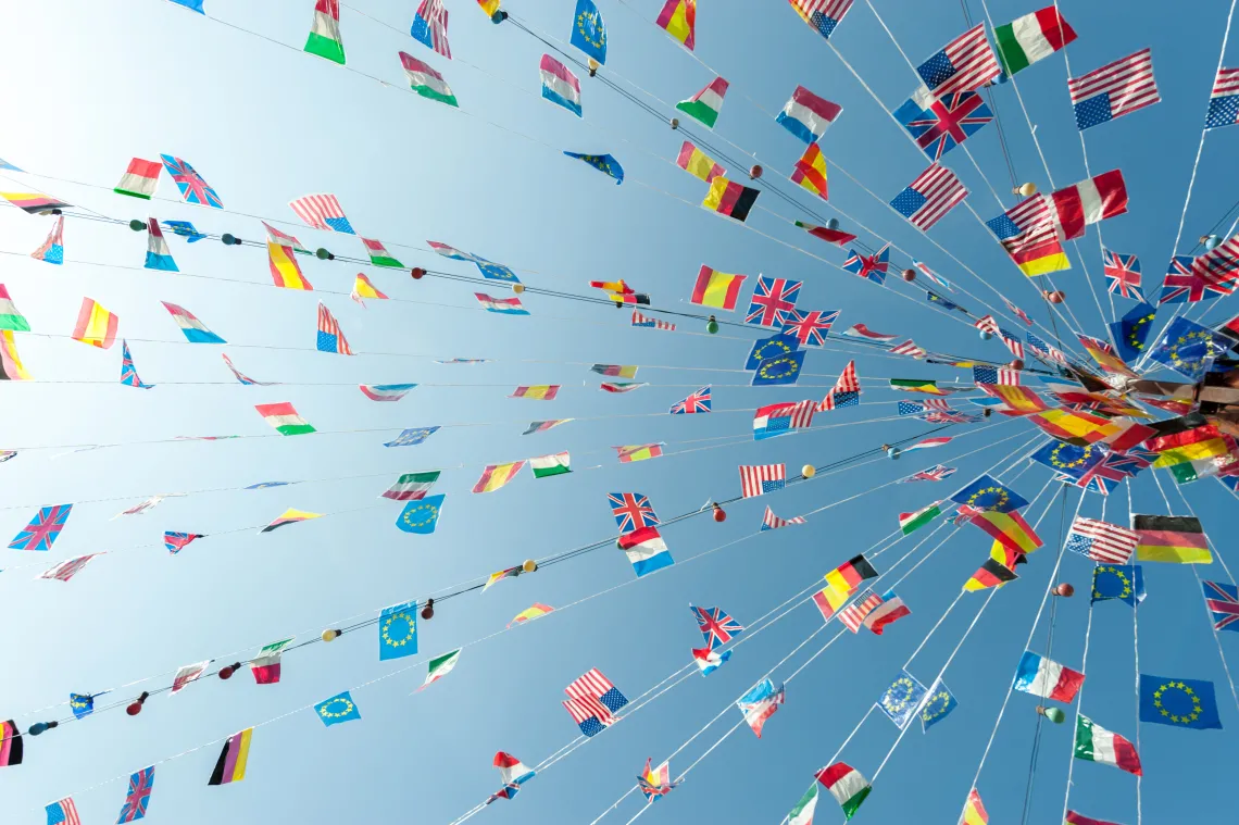 World flags hanging on strings that gather at a central point.