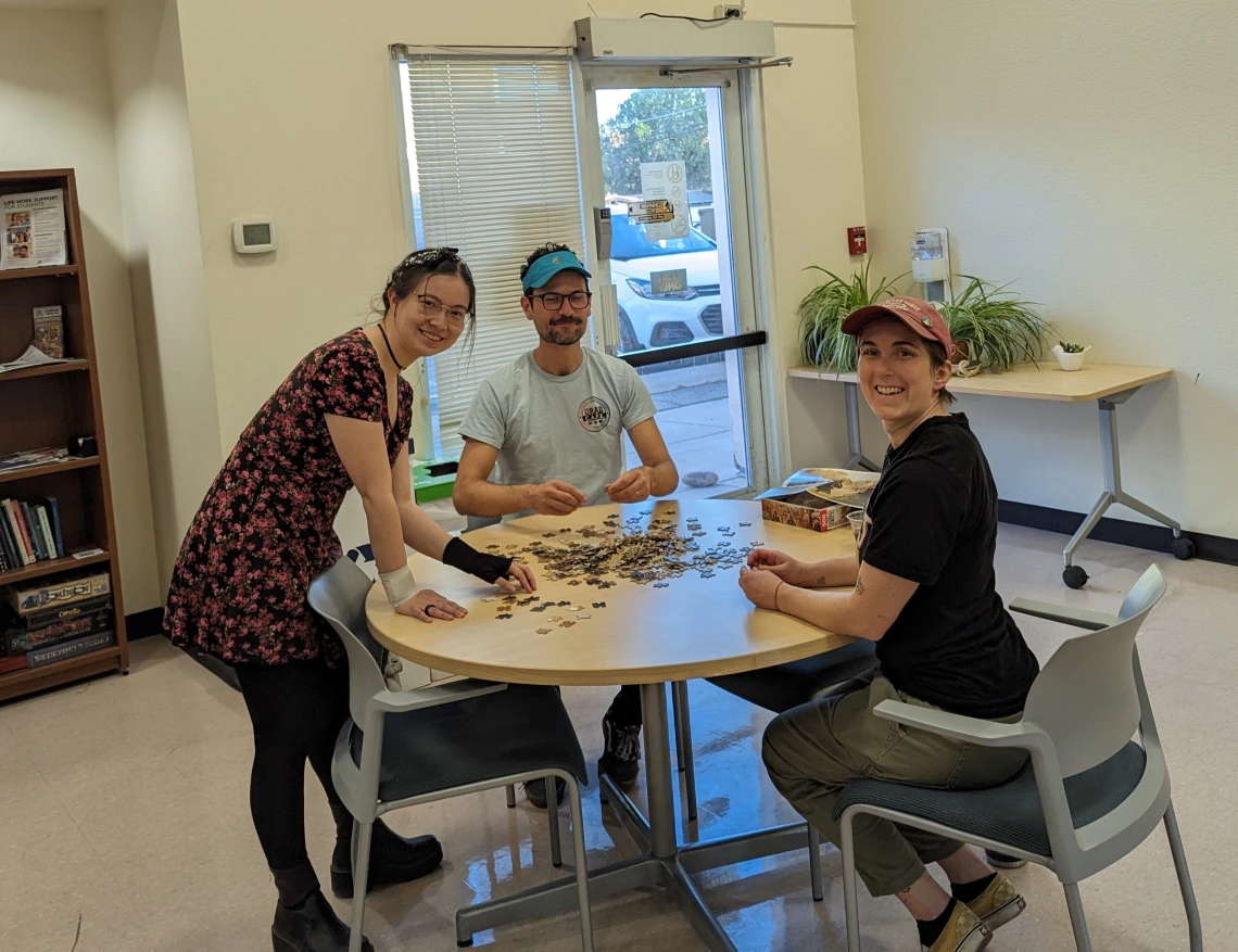 Grad SPACE students pose around a puzzle.
