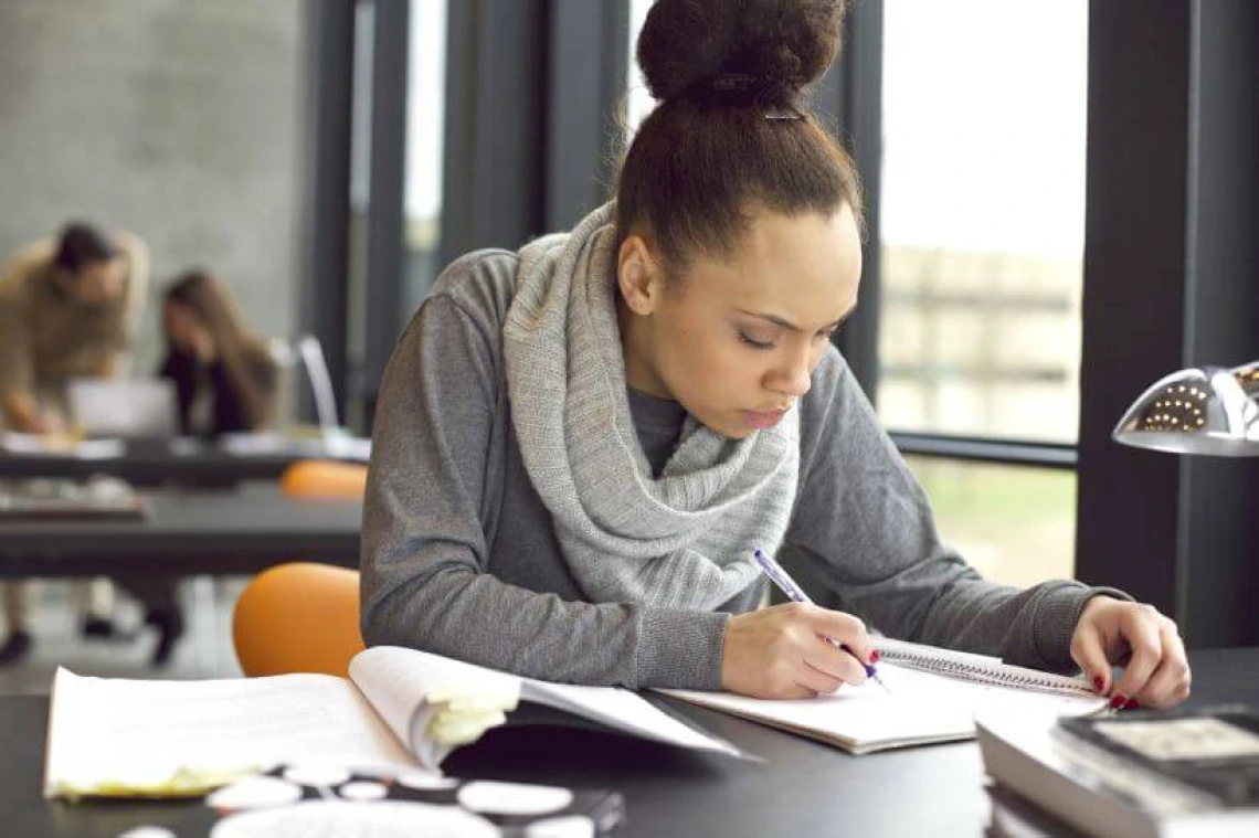 person focused and writing at desk