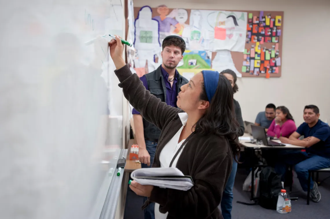 working at the board in a diverse classroom