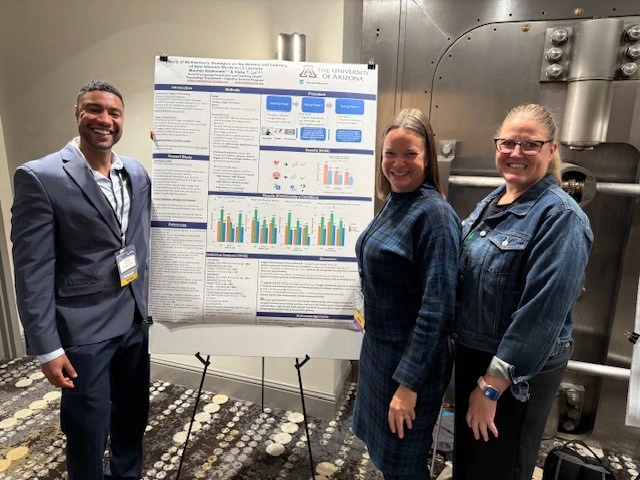 Mourad Abdennebi poses next to his poster with attendees and judges associated with the University of Arizona.