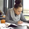 person focused and writing at desk