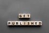 Wood block letters spelling out "Get Published" on a gray background.